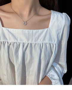 Gros plan du collier élégant en argent avec pendentif fleur en zircon sur un mannequin