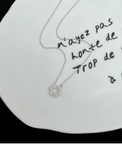 Détail du collier argenté avec pendentif flocon en zircons brillants sur assiette