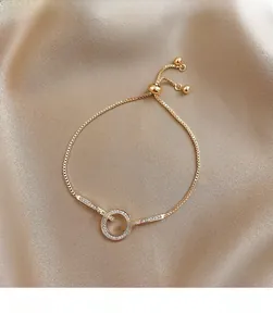 Detailweergave van een gouden schuifarmband met een glinsterende cirkel van micro-zirkonia