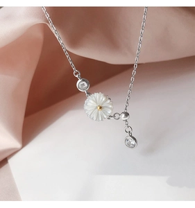 Detailed close-up of shell daisy pendant and zircon accents on S925 sterling silver chain
