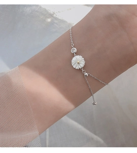 Close-up of a silver daisy bracelet with shell petals and adjustable drawstring chain