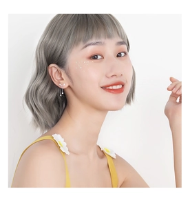 Boucles d'oreilles nœud argenté avec longues chaînes à pompons sur un mannequin asiatique