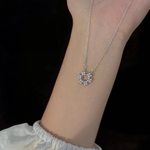 Collier argenté en forme de U avec pendentif floral et zircons porté par un mannequin