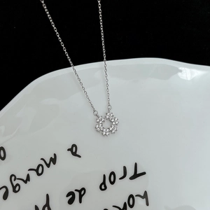 Collier élégant avec pendentif flocon de neige en zircons sur une assiette blanche