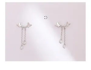 Vue détaillée des boucles d'oreilles nœud argentées avec longs pompons et zircons brillants