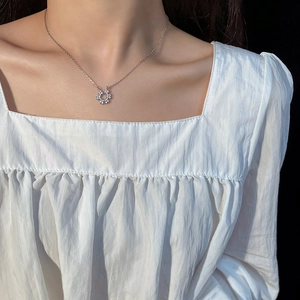 Collier élégant en argent avec pendentif fleur en zircon porté par un mannequin