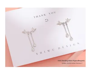 Détail des boucles d'oreilles nœud en argent S925 avec longs glands et zircon