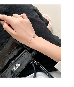 Makro-Detail des silbernen Doppelketten-Armbands mit einem funkelnden Kristallring