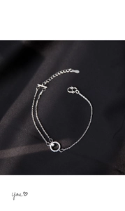 Makroaufnahme des silbernen Doppelarmbands mit Pavé-Kreis und rechteckigem Schmuckstein