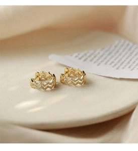 Macro shot of gold-plated wavy hoop earrings with micro-pave cubic zirconia stones