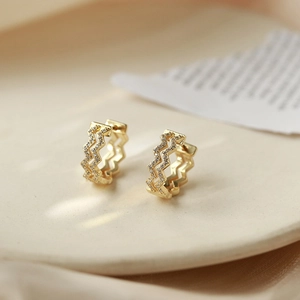 Elegant gold wave hoop earrings with micro-set zircon stones in a 45-degree side view