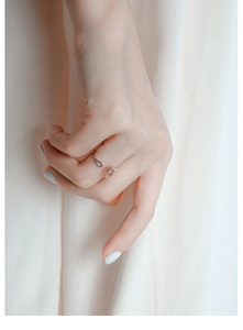 Gros plan d'une bague chat en argent S925 avec quartz fraise rose à la main