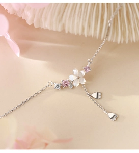 Makroaufnahme einer 925er Silber Kirschblütenkette mit Muschel-Blüten und Zirkonia-Herzen