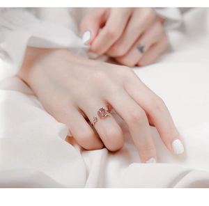Gros plan d'une bague chat en argent S925 avec perle de cristal fraise rose au doigt