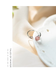 Macro d'une bague chat en argent s925 avec cristal fraise rose sur céramique