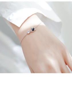 Bracciale con pianeta blu al polso con catena d'argento e ciondolo in cristallo