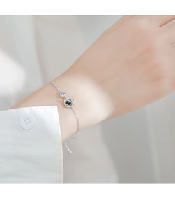 Dettaglio del bracciale in argento con pendente pianeta blu e zirconi sul polso
