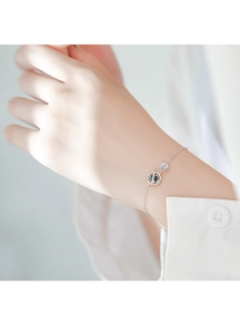 Dettaglio del bracciale argento con pianeta blu e zircone sul polso di una donna