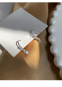 Macro view of S925 silver hoop earrings with zircon pavé and a square drop stone