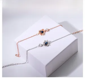 Dettaglio dei bracciali a pianeta in oro rosa e argento con pietre blu e cristalli