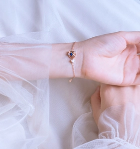 Dettaglio del bracciale Saturno in oro rosa con pietra blu e zirconi bianchi brillanti