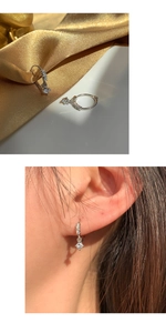 Detailed view of s925 silver hoop earrings with zircon pendant worn by a model