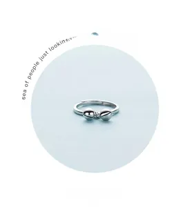 Detail of S925 sterling silver open ring featuring delicate twin bell charms