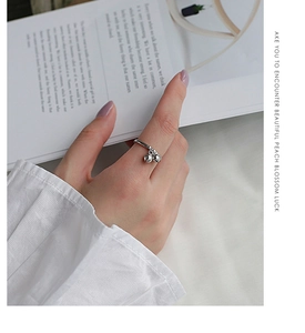 Close-up of S925 sterling silver ring featuring double bell charms on a model finger