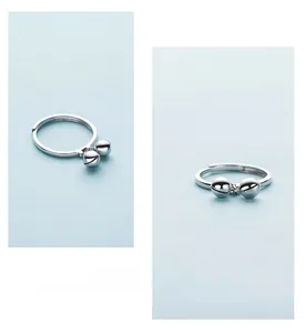 Detailed view of S925 sterling silver open ring featuring two elegant bell pendants