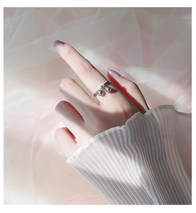 Close-up of minimalist S925 sterling silver ring with two dangling polished beads