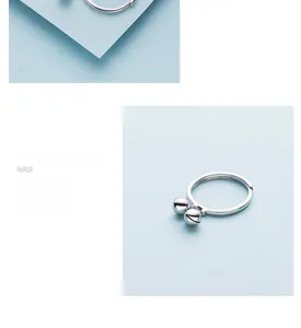 Detailed macro view of S925 sterling silver ring with twin bell charms and mirror polishing