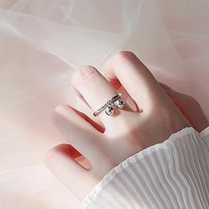 S925 sterling silver open ring with dual bell pendants worn on hand with soft lighting