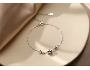 Détail macro du bracelet en argent S925 avec pendentif cylindre et chaîne réglable fine