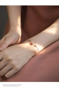 Gros plan d'un bracelet en argent s925 or rose avec pendentif cylindrique sur un poignet