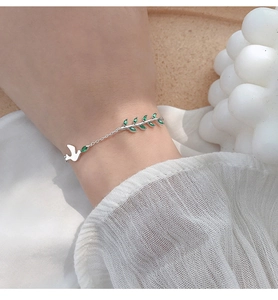 Détail du bracelet en argent S925 avec gemmes marquises vertes et breloque oiseau