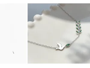 Détail du bracelet en argent S925 avec oiseau et gemmes vertes sur céramique