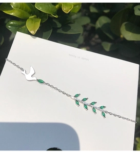 Détail du bracelet en argent S925 avec oiseau et branche de feuilles vertes serties