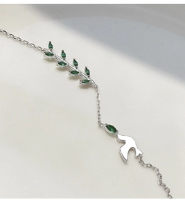 Détail macro du bracelet en argent S925 avec pierres marquises vertes sur branche et colombe