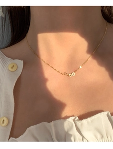 Gros plan du collier pendentif infini doré avec cristaux micro-pavés sur le cou