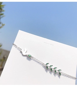 Détail du charm oiseau en argent et de la branche verte sur bracelet en argent sterling