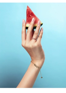 Gros plan sur la bague feuille en argent s925 et le bracelet branche en émail vert