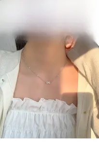 Détail du collier pendentif infini avec micro-pavé de cristaux sur le cou du modèle