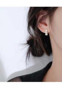 Gros plan de petites boucles d'oreilles huggie en argent 925 avec zircons floraux