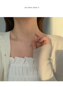 Détail du pendentif infini avec cristaux sertis sur un collier minimaliste en argent fin