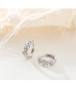 Vue macro des boucles d'oreilles fleurs en argent S925 avec des zircons scintillants