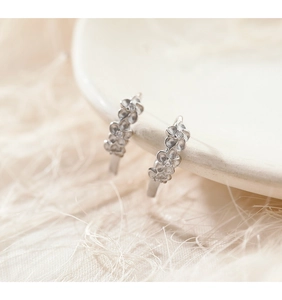 Vue détaillée des boucles d'oreilles fleur à cinq pétales en argent avec zircon