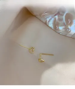 Detailed close-up of hollow heart-shaped silver earrings with elegant golden finish