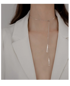 Detail of silver S925 geometric triangle tassel choker on model neck in white suit