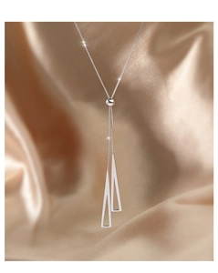 Macro detail of S925 silver geometric triangle necklace with adjustable slider on champagne satin