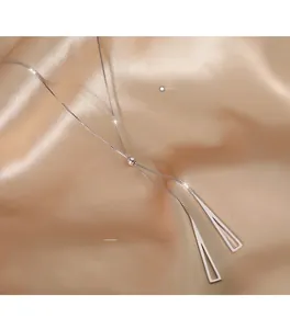 Detailed close-up of S925 sterling silver geometric triangle necklace on silk